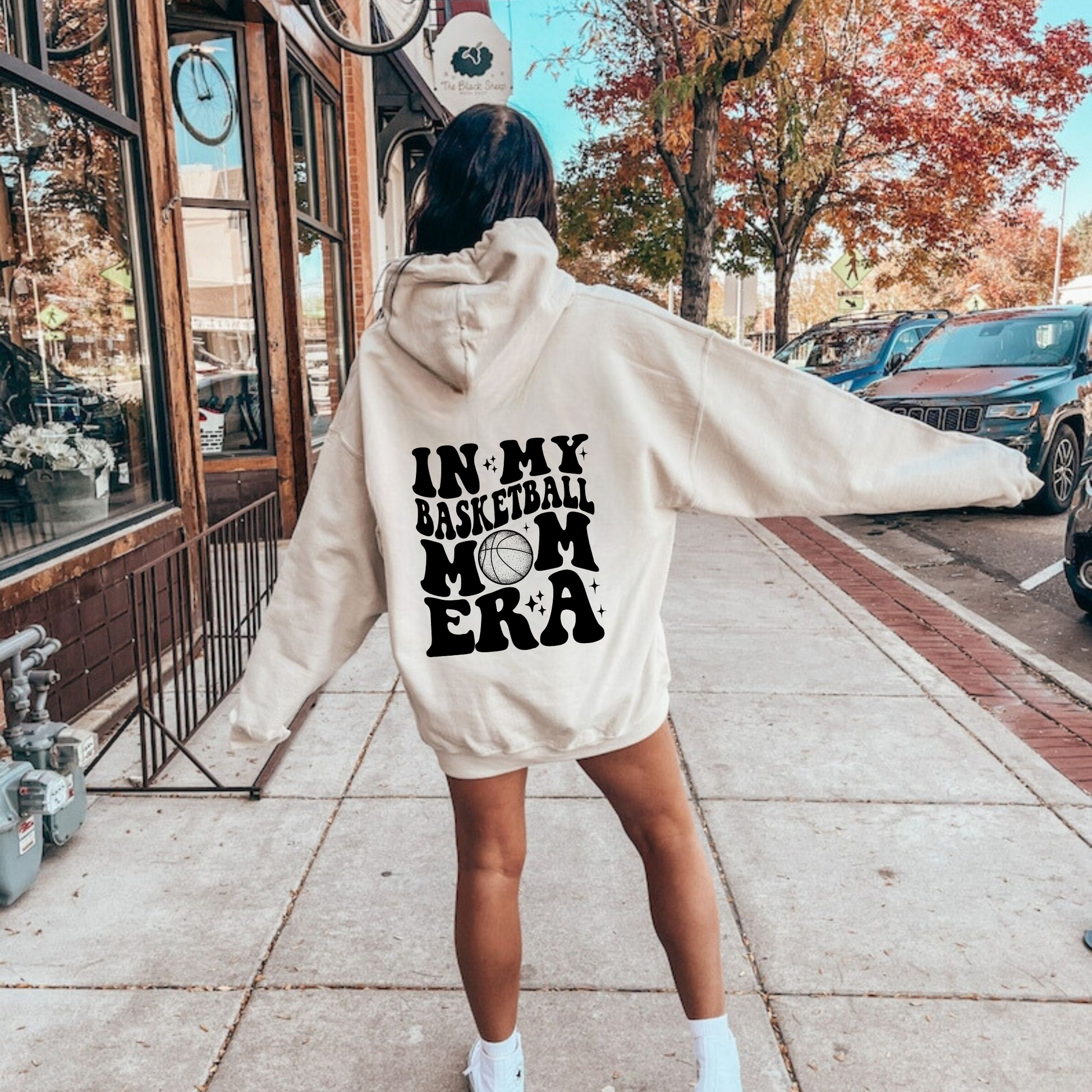 A cozy oversized hoodie for basketball mamas with the text 'In My Basketball Mom Era'. This sweatshirt is ideal for game day, offering comfort and style for basketball moms supporting their players.