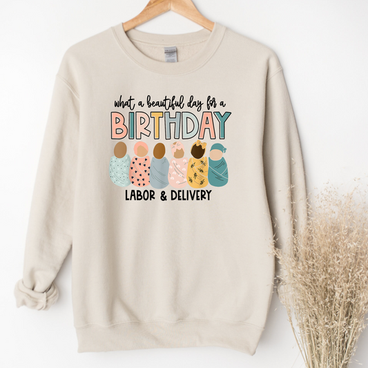 A Labor and Delivery Nurse Crewneck Sweatshirt with the text "It's a beautiful day for a birthday". This nurse sweater is designed for RNs and registered nurses working in labor and delivery (L&D). Showcase your style and dedication as an L&D nurse with this cute and comfortable nurse sweatshirt. Shop now and add this unique OB Nurse sweatshirt to your nurse clothes collection.