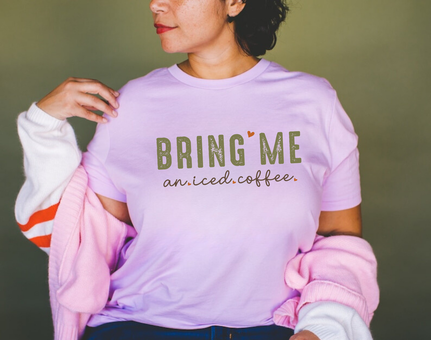 A close-up image of a women's coffee shirt with the text "Bring Me an Iced Coffee" printed on it. The shirt is displayed on a white background and features a stylish and humorous design. Perfect for coffee lovers and summer outfits. 