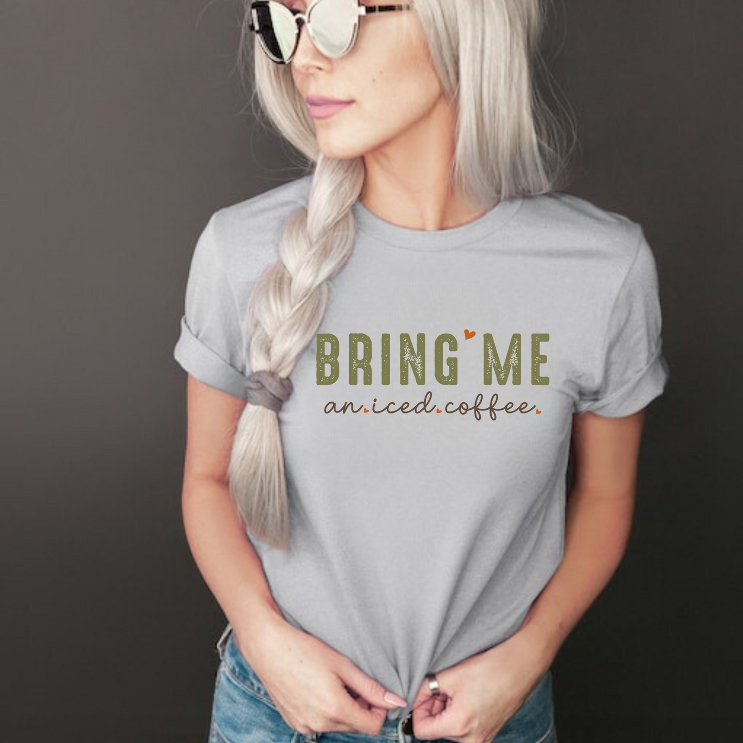 A close-up image of a women's coffee shirt with the text "Bring Me an Iced Coffee" printed on it. The shirt is displayed on a white background and features a stylish and humorous design. Perfect for coffee lovers and summer outfits. 