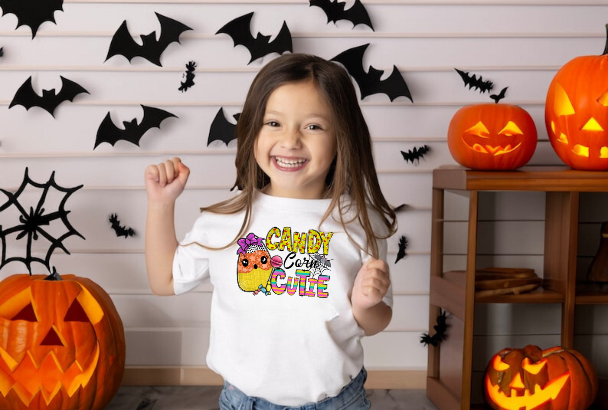 An adorable Halloween shirt for girls with the phrase 'Candy Corn Cutie', featuring a preppy and playful design. The shirt adds a unique touch to her Halloween outfit, embodying the essence of cute Halloween fun.