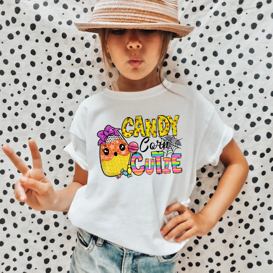 An adorable Halloween shirt for girls with the phrase 'Candy Corn Cutie', featuring a preppy and playful design. The shirt adds a unique touch to her Halloween outfit, embodying the essence of cute Halloween fun.