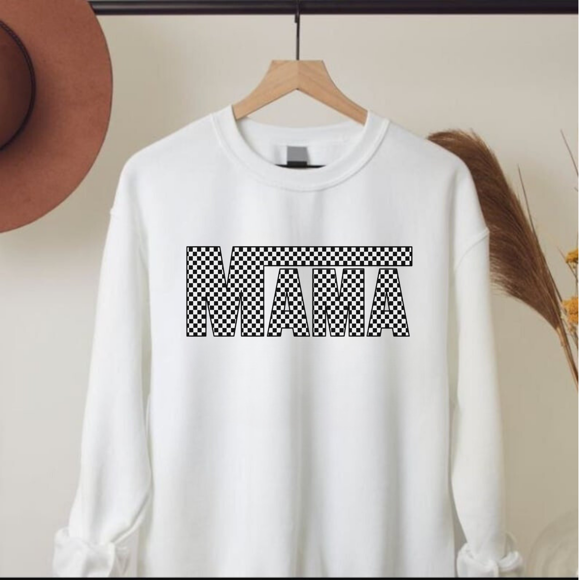 A cozy and stylish checker print mama crewneck sweatshirt. This oversized and comfy sweatshirt is perfect for moms, featuring a trendy checkerboard print design. Shop now and add this cute and cozy mama crewneck sweatshirt to your mom wardrobe.