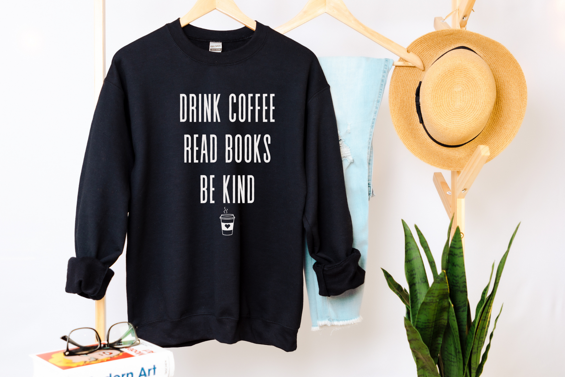 An oversized book lovers sweatshirt with the phrase "Drink Coffee, Read Books, Be Kind" written in bold letters. Perfect for book enthusiasts and lovers of literature.