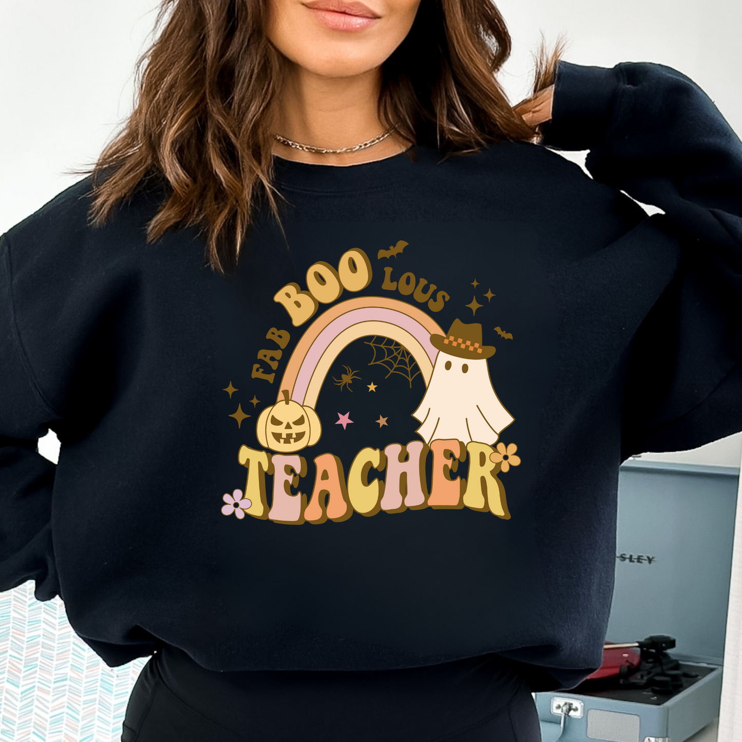 A cozy Halloween teacher sweatshirt, perfect for embracing the seasonal spirit while maintaining a professional teacher style. The sweatshirt features Halloween-themed design elements that add a touch of festive charm to your fall teacher outfit.