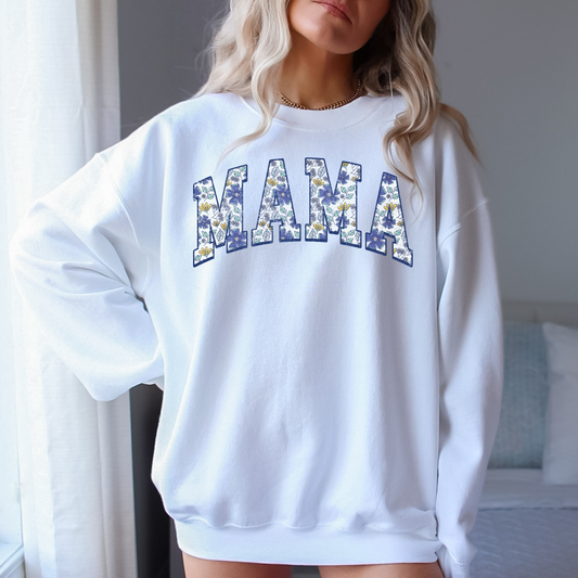 A floral varsity Mama crewneck sweatshirt, offering a casual and comfy style. The sweatshirt features a charming floral design with a varsity letter vibe, perfect for a cute and cozy mom outfit.