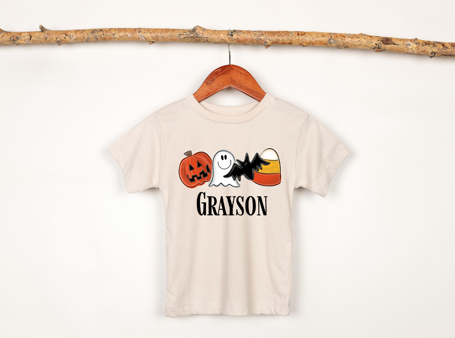 A personalized Halloween shirt for kids with a cute ghost design and their name, adding a unique and preppy touch to their Halloween outfit. The shirt embodies the spirit of Halloween with a playful 'boo' charm and pumpkin accents.