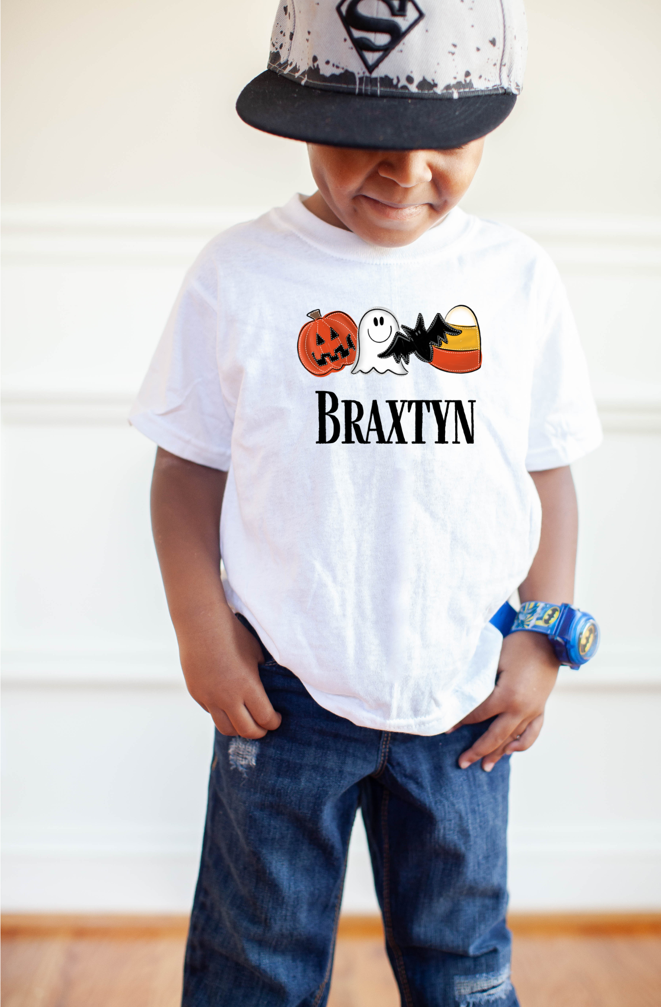 A personalized Halloween shirt for kids with a cute ghost design and their name, adding a unique and preppy touch to their Halloween outfit. The shirt embodies the spirit of Halloween with a playful 'boo' charm and pumpkin accents.