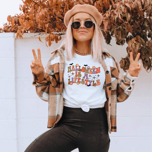 A retro Halloween shirt with the text 'Halloween Is A Lifestyle', featuring a design that captures the essence of the spooky season. The shirt adds a touch of autumn charm and Halloween aesthetic to your fall outfit.