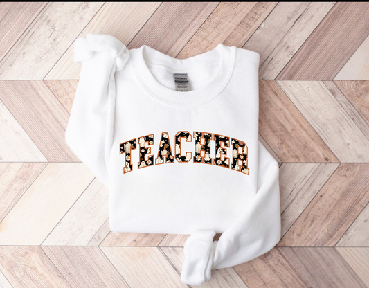 A cozy Halloween teacher sweatshirt, perfect for embracing the seasonal spirit while maintaining a professional teacher style. The sweatshirt features Halloween-themed design elements that add a touch of festive charm to your fall teacher outfit.