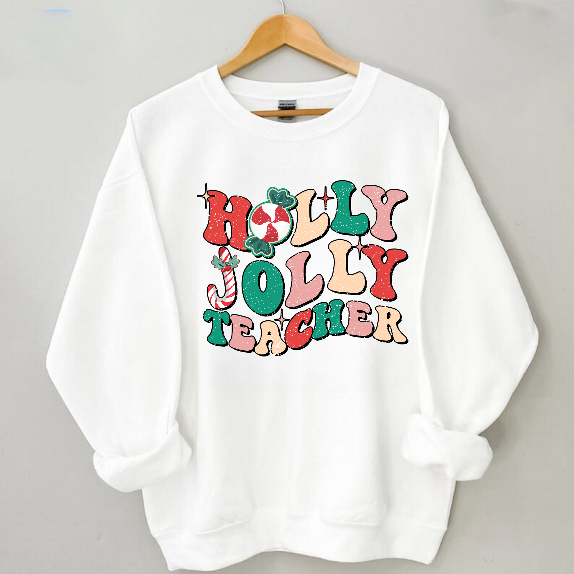 A cute and trendy 'Holly Jolly Teacher' Retro Christmas sweatshirt, perfect for embracing the festive season with a touch of retro charm. The sweater is designed for teachers who want to add holiday cheer to their winter style.