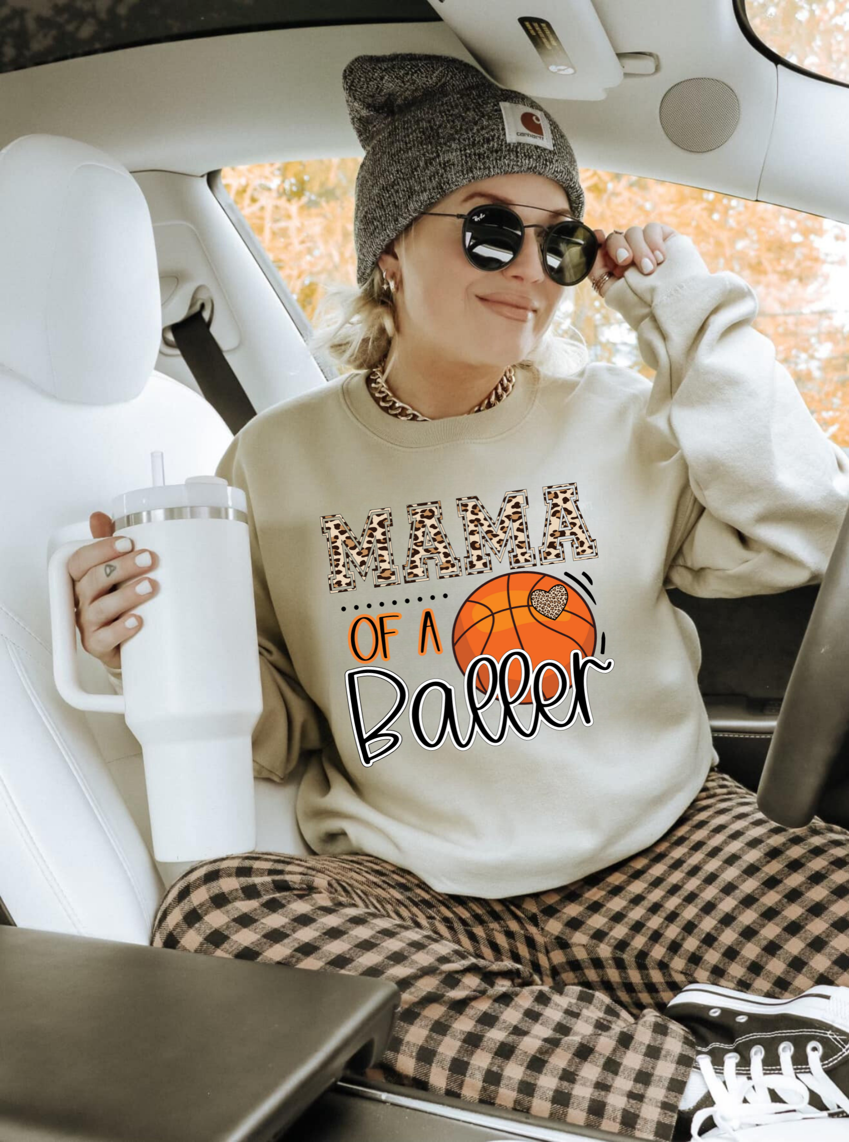 A cozy crewneck sweatshirt for basketball moms with the text 'Mama of a Baller'. This sweatshirt is perfect for game day, offering comfort and style for basketball moms supporting their players.