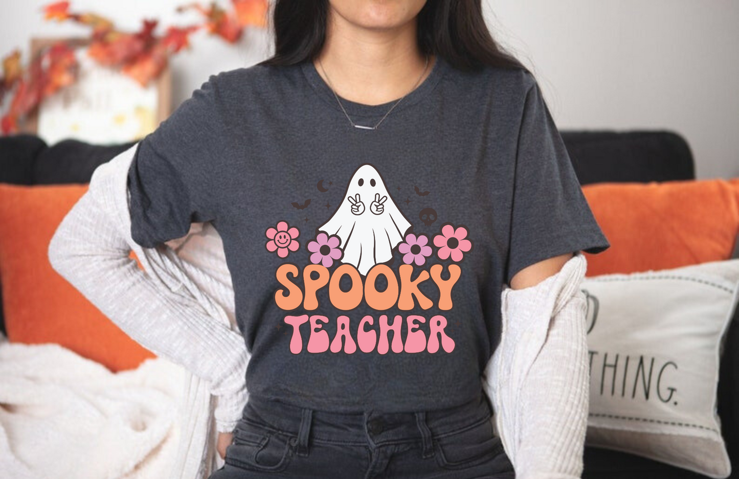 A cozy 'Spooky Teacher' Halloween shirt, perfect for teachers looking to embrace the autumn spirit. The shirt features a playful design that adds a touch of Halloween charm to your fall outfit. Ideal for showcasing your teacher style with a dash of spooky fun.